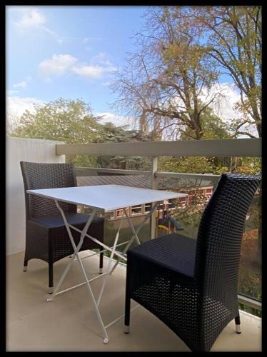 une table et deux chaises sur un balcon dans l'établissement Le p'tit Beauce au Cœur de Chartres, à Chartres