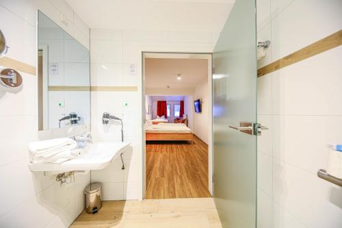 a bathroom with a sink and a shower at Hotel Lafette in Hinterzarten