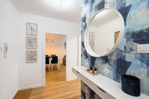 einen Wandspiegel im Wohnzimmer in der Unterkunft Bliska Wola Navy Blue Business Apartment in Warschau