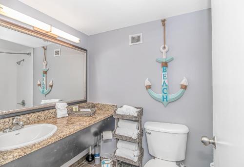 a bathroom with a sink and a toilet and a mirror at Landmark 830 in Myrtle Beach