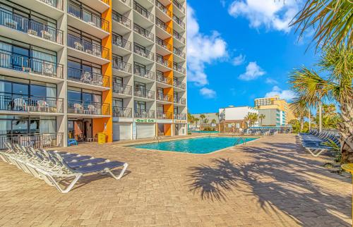 a hotel with a swimming pool and lounge chairs at Landmark 830 in Myrtle Beach