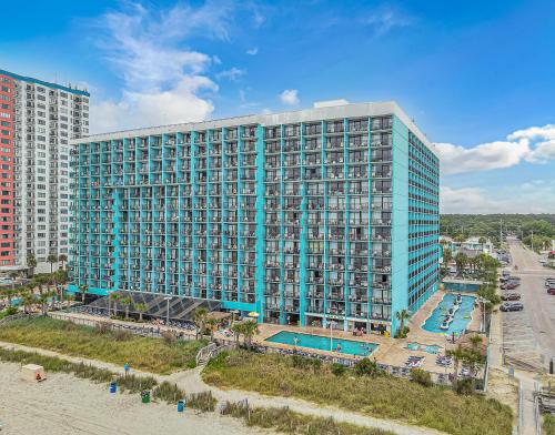 a large blue building with a swimming pool next to a beach at Landmark 830 in Myrtle Beach
