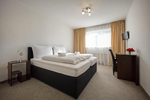 a hotel room with a large bed and a window at HOTEL Garni PATRIOT in Trnava