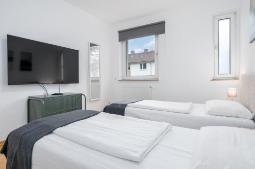 Cette chambre blanche dispose de 2 lits et d'une télévision à écran plat. dans l'établissement CASSEL LOFTS - Gehobene Monteurwohnung für 4 - nähe Uni, Klinikum, Industriepark Mittelfeld, à Cassel