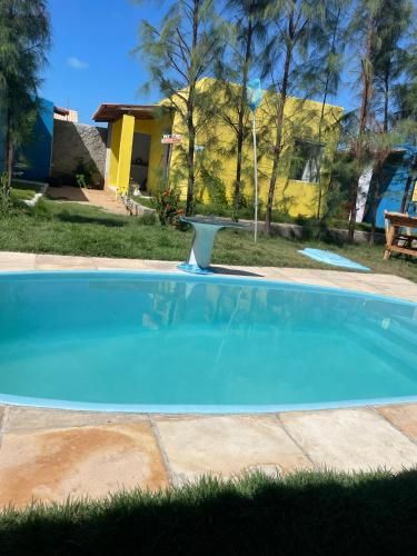 una piscina azul con un baño de aves en un patio en Suítes Gold Star Village, en Majorlândia