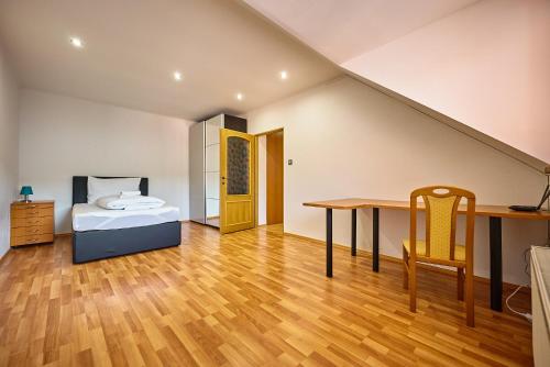 a bedroom with a bed and a desk and a table at HOTEL Garni PATRIOT in Trnava
