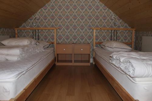 two beds in a room with a wall at Skillingaryds Gård in Skillingaryd