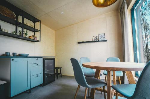 a dining room with a table and blue chairs at Venejoen Piilo - Naava in Romppala