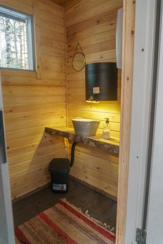 a room with a television and a counter in a wooden room at Venejoen Piilo - Naava in Romppala