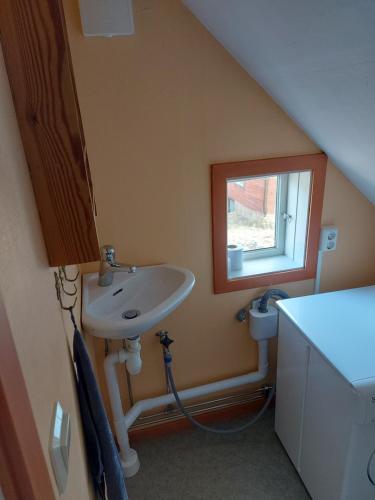 baño con lavabo y ventana en Mariannelund cottage, en Mariannelund