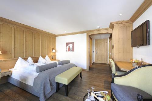 a hotel room with a bed and a desk at ERMITAGE Wellness- & Spa-Hotel in Gstaad