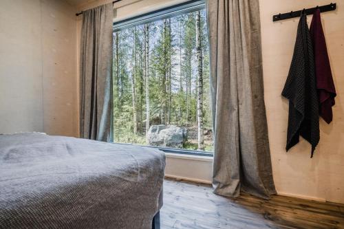 - une chambre avec un lit et une grande fenêtre dans l'établissement Venejoen Piilo - Naava, à Romppala