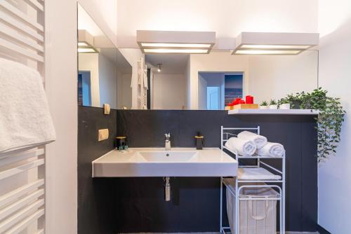 a bathroom with a white sink and a mirror at Apartament DREAM in Pogorzelica