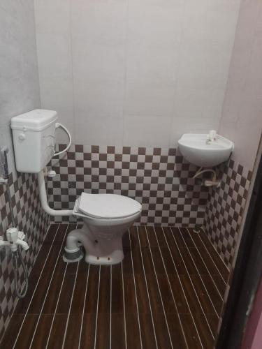 a bathroom with a toilet and a sink at AKSHITA Guest House in Guwahati