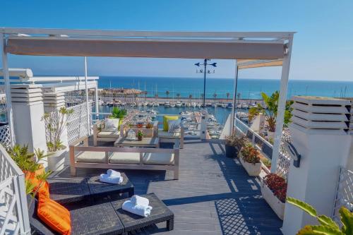 d'un balcon avec des canapés et une vue sur l'océan. dans l'établissement The Moonlight Sea View by Hello Homes Sitges, à Barcelone