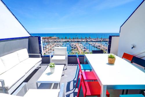 a balcony with tables and a view of the beach at The Moonlight Sea View by Hello Homes Sitges in Barcelona