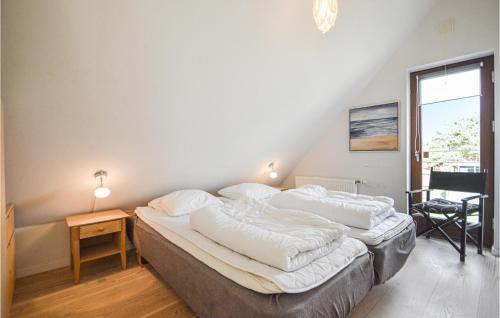 1 dormitorio con 2 camas, mesa y ventana en 3 Bedroom Amazing Home In Rm, en Rømø Kirkeby