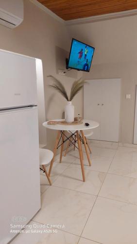 uma sala de estar com uma mesa e uma televisão na parede em Elise Corfu City Apartment em Ágios Rókkos