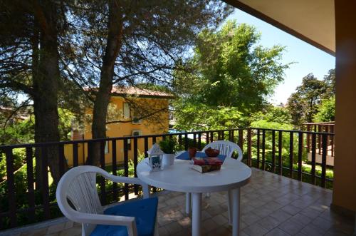 a patio with a table and chairs on a balcony at Villaggio Dei Gelsomini in Bibione