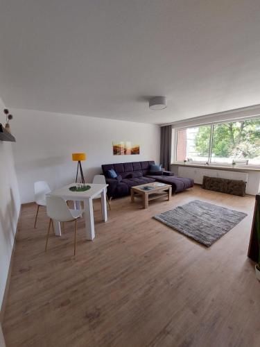 een woonkamer met een bank en een tafel bij Fewo am Kurpark mit Balkon in Wilhelmshaven