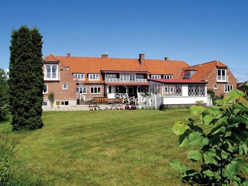 una casa grande con un gran patio delante en Hotel Lolland, en Nørreballe