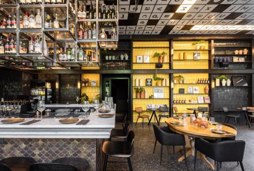 a restaurant with a table and chairs and a bar at Play Midtown Hotel Tel Aviv in Tel Aviv