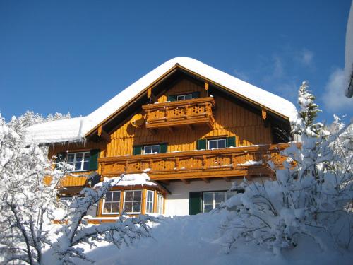 een blokhut in de sneeuw met sneeuw bedekte bomen bij Haus Schrei in Grundlsee