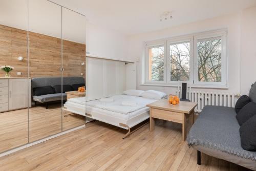 a bedroom with a bed and a living room at Cozy studio in Downtown Gdańsk by Renters in Gdańsk