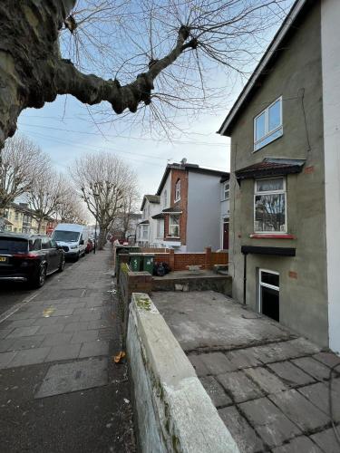 a house on a street with cars parked in front of it at Upton Park Bedrooms 25 min to Central London in London
