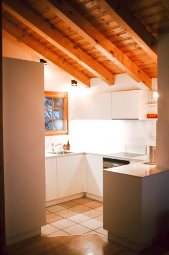 a kitchen with white cabinets and a sink at Chalet le Joyau in Nendaz - Sleeps 6 - Panoramic Views - 4 Vallées in Nendaz
