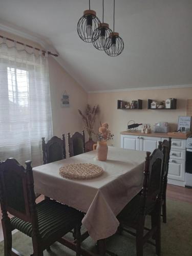 a dining room table with a white table cloth on it at Apartman Bepo in Gospić