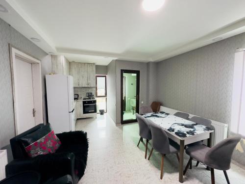 eine Küche und ein Wohnzimmer mit einem Tisch und Stühlen in der Unterkunft Villa B Barleon-Bakuriani in Bakuriani