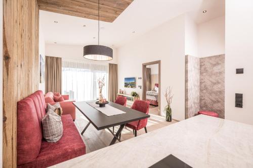 a living room with a red couch and a table at Die Zillertalerin in Uderns