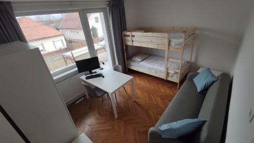 a small room with a couch and a desk with a computer at Vila Gajdo in Tvrdošovce