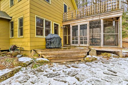 a yellow house with a deck on the front of it at Cozy Monterey Home with Porch Walk to Lake Garfield in Monterey