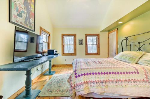 a bedroom with a bed and a desk with a television at Cozy Monterey Home with Porch Walk to Lake Garfield in Monterey