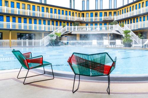 two chairs in front of a building with a pool at Molitor Paris - MGallery Hotel Collection in Paris
