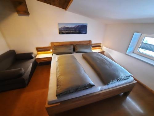 a bedroom with a large bed and a couch at Appartements Anfang in Weerberg