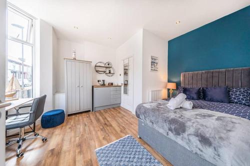 a bedroom with a bed and a desk and a table at Stunning house close to the stadium + Hot tub! in Liverpool