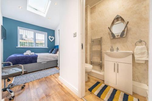 a bedroom with a bed and a sink and a mirror at Stunning house close to the stadium + Hot tub! in Liverpool