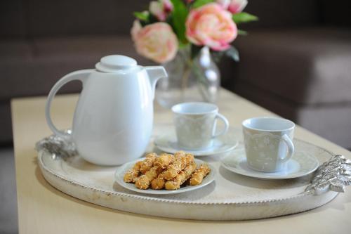 a tray with cups and cookies on a table with flowers at Memories... in Iraklitsa