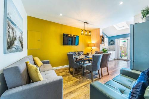 a living room with a couch and a dining room at Stunning house close to the stadium + Hot tub! in Liverpool