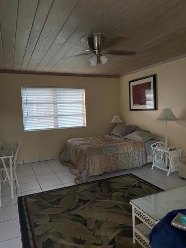a bedroom with a bed and a ceiling fan at The Grove in Delray Beach