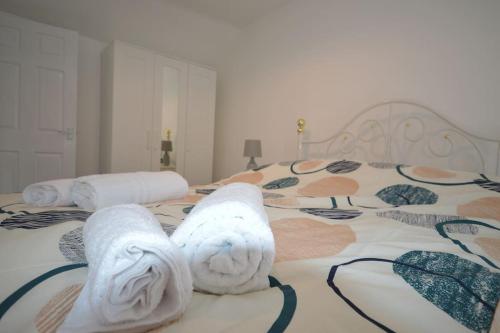 a bed with white towels on top of it at Mountain Escape - Cosy 2 bed house in Afan Valley in Port Talbot