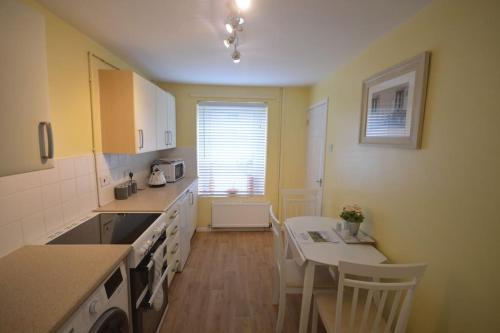 a kitchen with a table and a dining room at Mountain Escape - Cosy 2 bed house in Afan Valley in Port Talbot