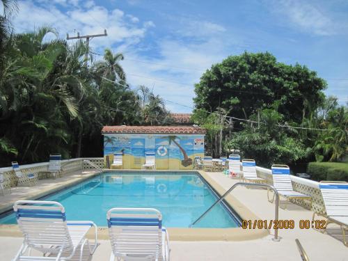 a swimming pool with lounge chairs and a swimming pool at The Grove in Delray Beach