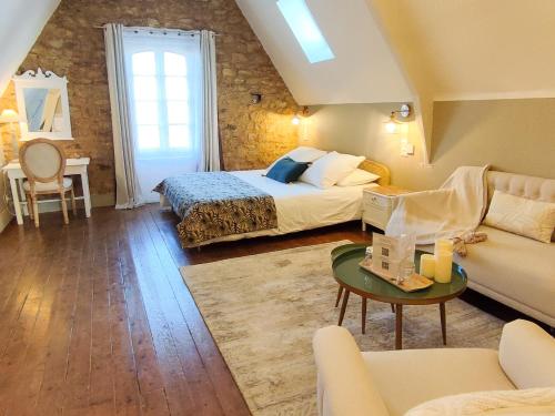 a bedroom with a bed and a couch and a table at Chambres d'Hotes Le 1900 in Val Couesnon