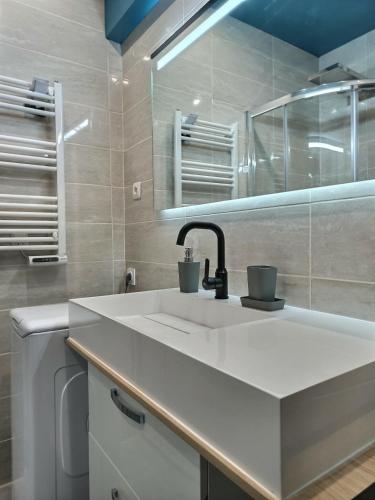 une salle de bain blanche avec un lavabo et un miroir dans l'établissement Le Coquelicot - Hyper-Centre - Wifi - Calme, à Albi