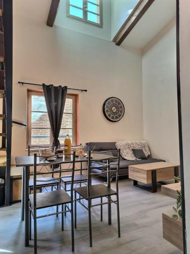 un salon avec une table, des chaises et un canapé dans l'établissement Le Coquelicot - Hyper-Centre - Wifi - Calme, à Albi