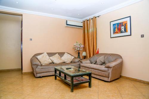 a living room with two couches and a coffee table at Midindi Hotel in Accra